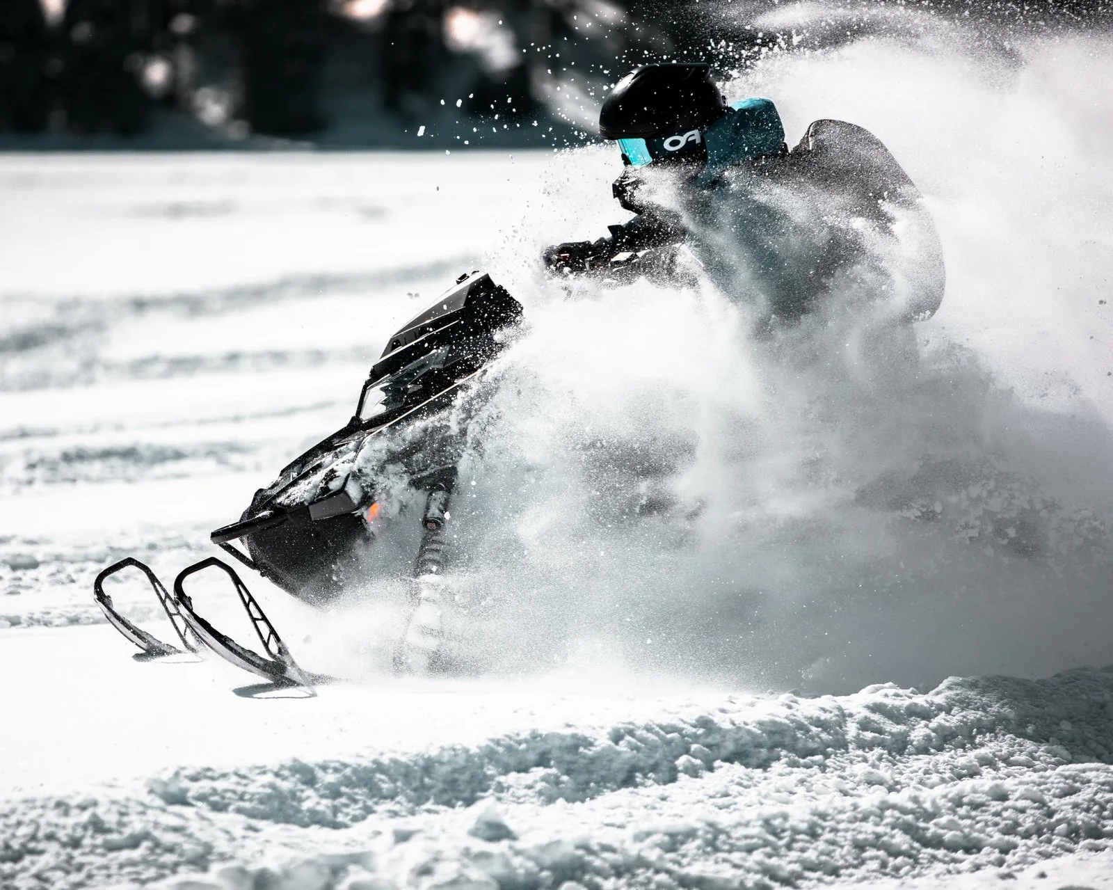 Snowmobile throwing powder in a snow field